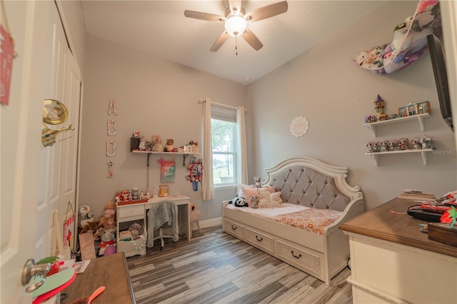 bedroom with light hardwood / wood-style floors, vaulted ceiling, and ceiling fan