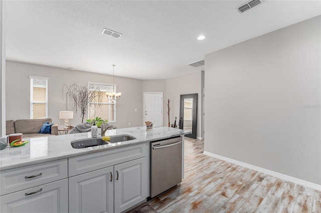 kitchen featuring pendant lighting, a textured ceiling, light hardwood / wood-style floors, sink, and stainless steel dishwasher