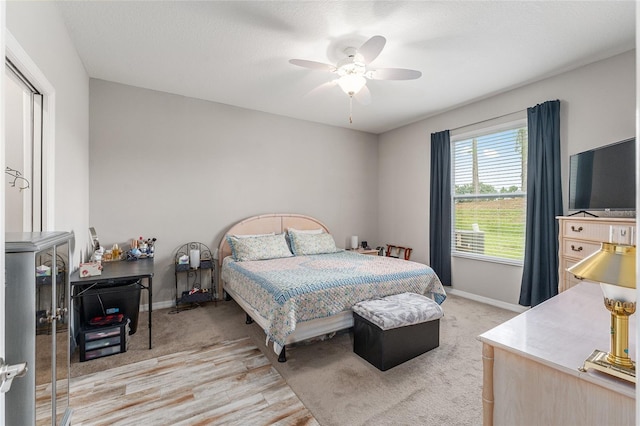 bedroom with light hardwood / wood-style flooring, ceiling fan, and a textured ceiling