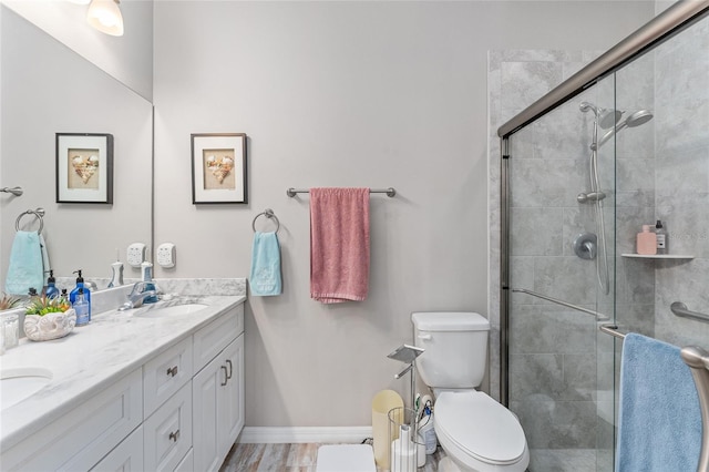 bathroom featuring hardwood / wood-style floors, vanity, toilet, and a shower with door