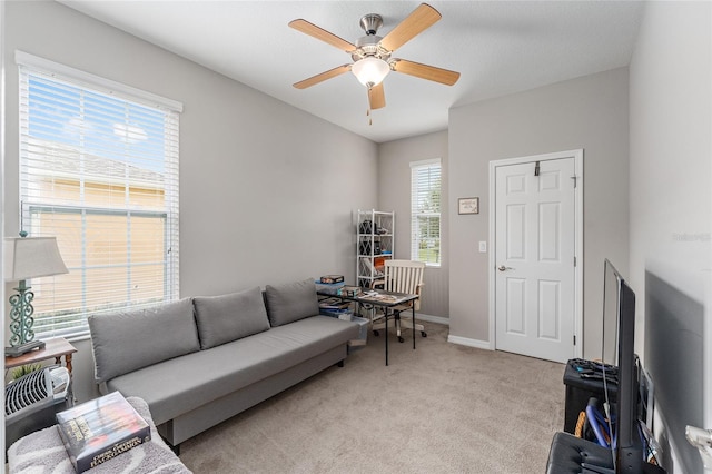 living room featuring a wealth of natural light, ceiling fan, and light colored carpet