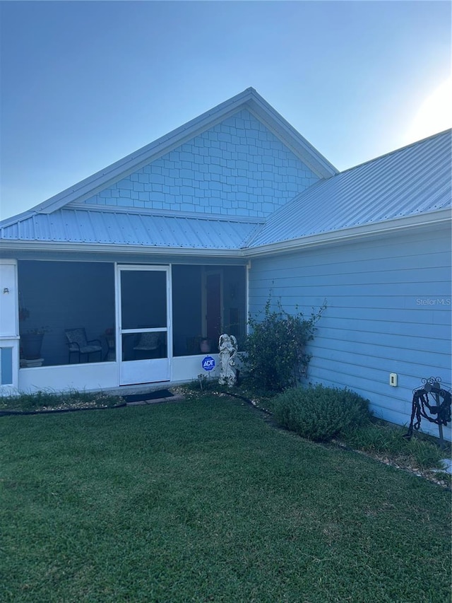 back of house featuring a sunroom and a yard