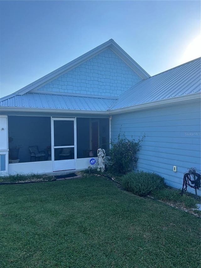 104 Turtle Run, Umatilla, FL 32784 - rear view of property featuring a lawn, metal roof, and a sunroom