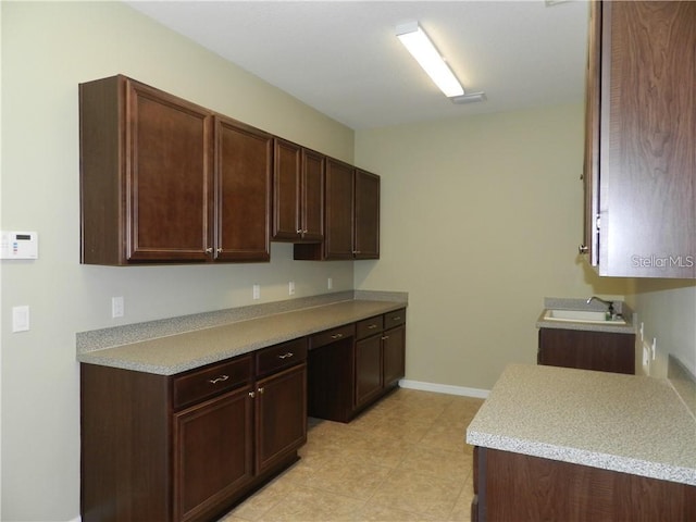 kitchen featuring dark brown cabinetry and sink