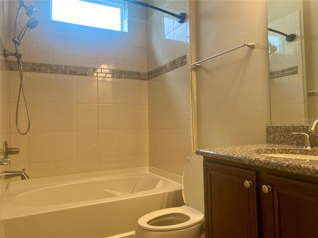 full bathroom with toilet, vanity, and tiled shower / bath