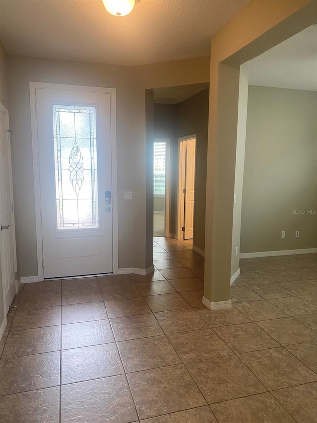 entrance foyer featuring tile patterned flooring and a healthy amount of sunlight