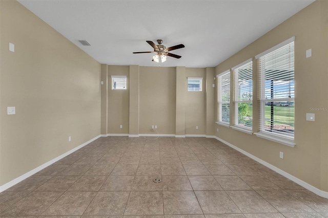 tiled empty room featuring ceiling fan