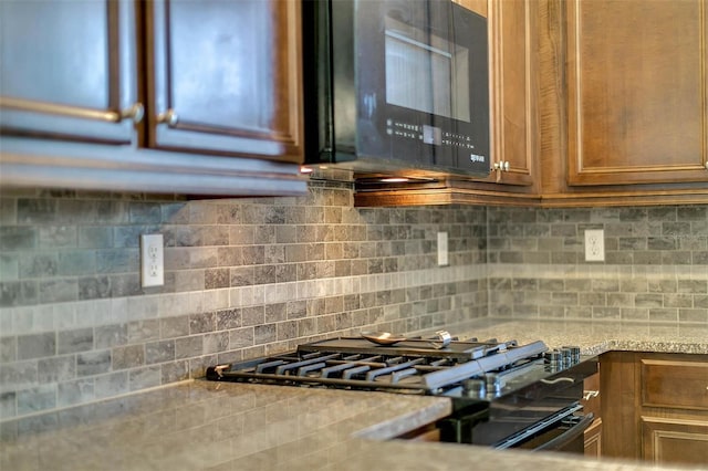 kitchen with backsplash and black appliances