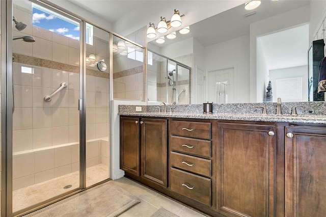 bathroom with vanity, a shower with shower door, and tile patterned flooring