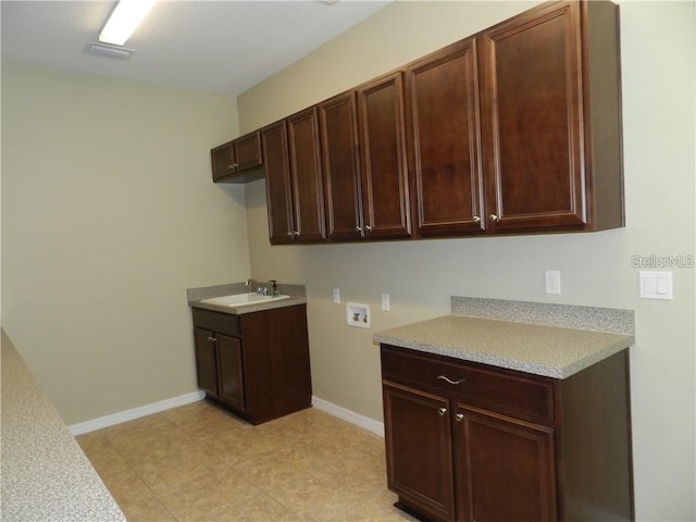 laundry room featuring light tile patterned flooring, cabinets, hookup for a washing machine, and sink