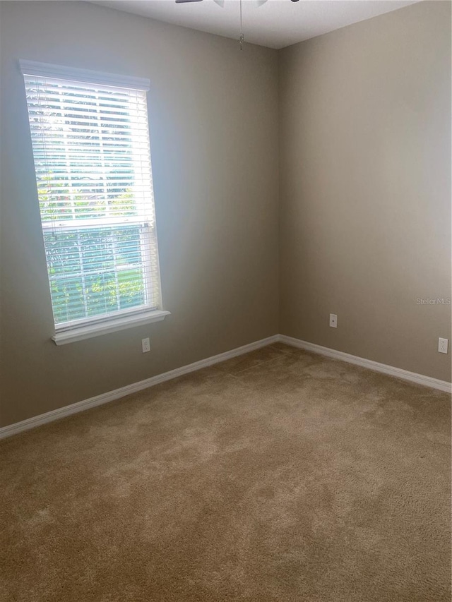 carpeted empty room featuring ceiling fan