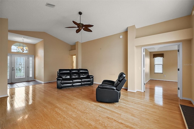 living room featuring light hardwood / wood-style floors, vaulted ceiling, and ceiling fan