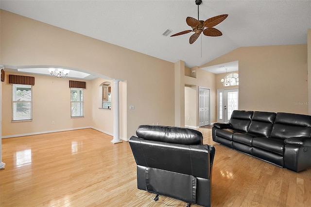 living room with lofted ceiling, ornate columns, ceiling fan with notable chandelier, and light wood-type flooring