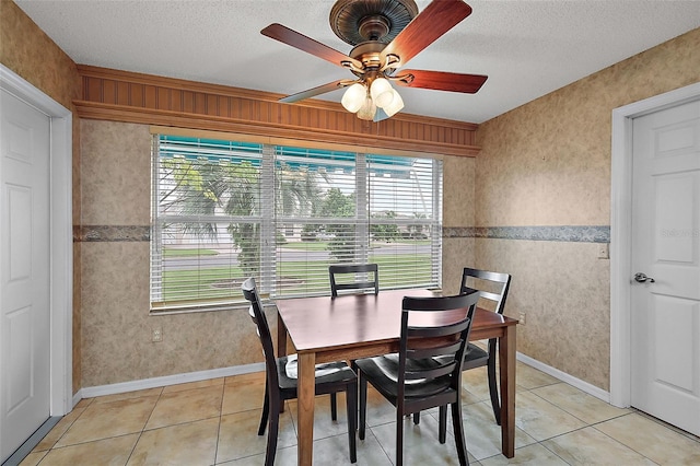 dining space featuring a textured ceiling, light tile patterned floors, and ceiling fan