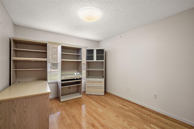 unfurnished bedroom with light hardwood / wood-style flooring and a textured ceiling