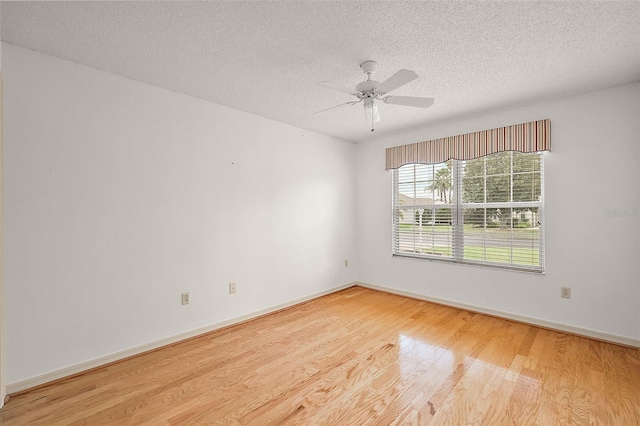 unfurnished room with a textured ceiling, light wood-type flooring, and ceiling fan