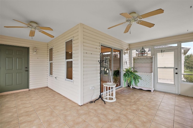 unfurnished sunroom featuring ceiling fan