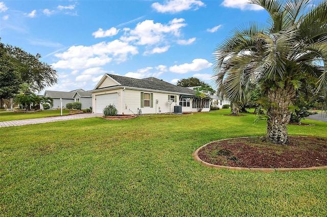 ranch-style home with central air condition unit, a front lawn, and a garage