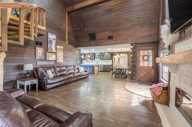 living room featuring wood-type flooring, wood walls, sink, and high vaulted ceiling