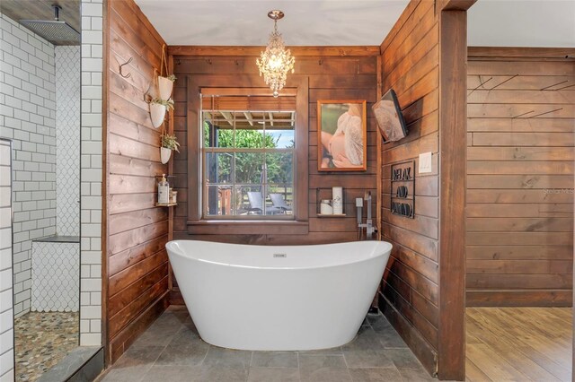 bathroom with a notable chandelier, wood walls, independent shower and bath, and hardwood / wood-style floors