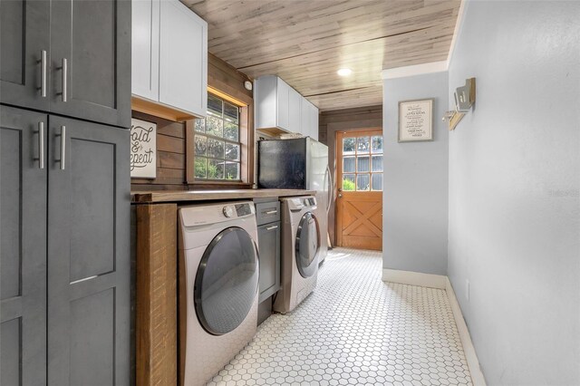 laundry area featuring wooden ceiling, separate washer and dryer, and cabinets