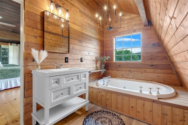 bathroom with hardwood / wood-style flooring, a notable chandelier, wooden walls, vanity, and a bathing tub