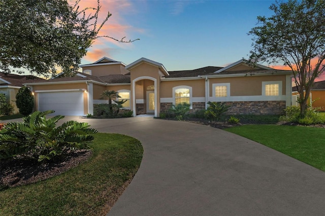 view of front of property with a garage and a lawn