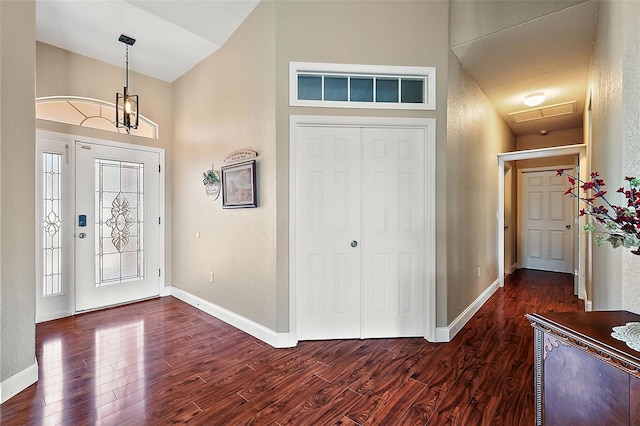 entrance foyer with a healthy amount of sunlight, dark hardwood / wood-style floors, and a chandelier