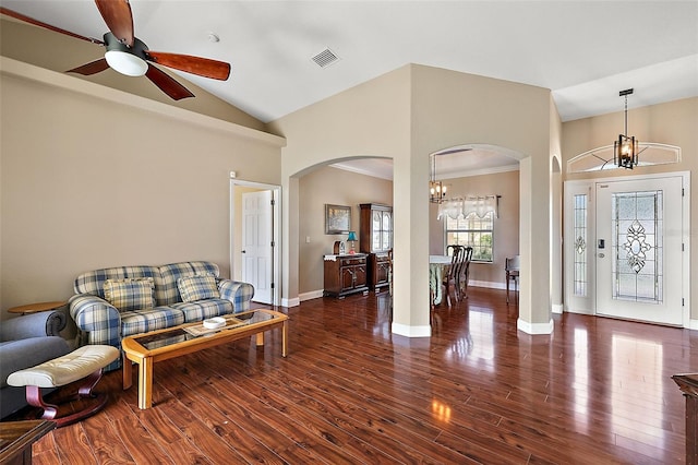 living room featuring ceiling fan with notable chandelier, lofted ceiling, ornamental molding, and dark hardwood / wood-style flooring