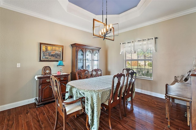 dining room featuring a tray ceiling, crown molding, an inviting chandelier, and dark hardwood / wood-style flooring