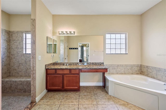 bathroom featuring tile patterned flooring, shower with separate bathtub, vanity, and a wealth of natural light