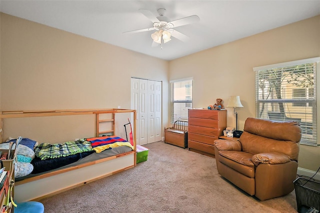 bedroom with ceiling fan, a closet, and light carpet