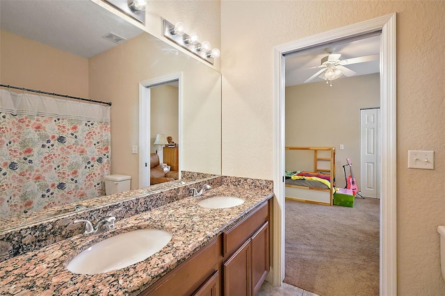 bathroom featuring vanity, toilet, and ceiling fan