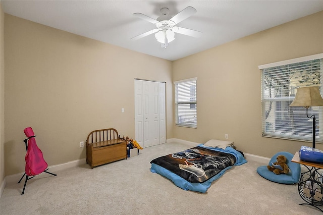 bedroom with a closet, light colored carpet, and ceiling fan