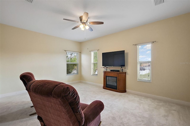 living room with light carpet, a healthy amount of sunlight, and ceiling fan