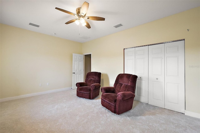 living area featuring light carpet and ceiling fan