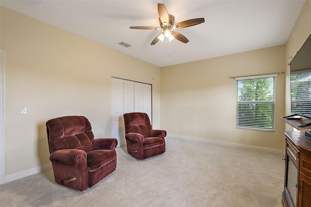 living area with ceiling fan and light colored carpet