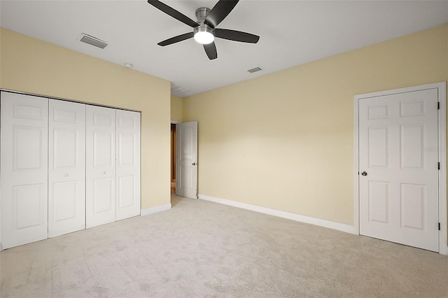 unfurnished bedroom featuring light carpet, a closet, and ceiling fan