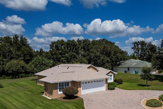 single story home with a garage and a front lawn