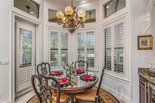 dining area with crown molding, a chandelier, wine cooler, and plenty of natural light