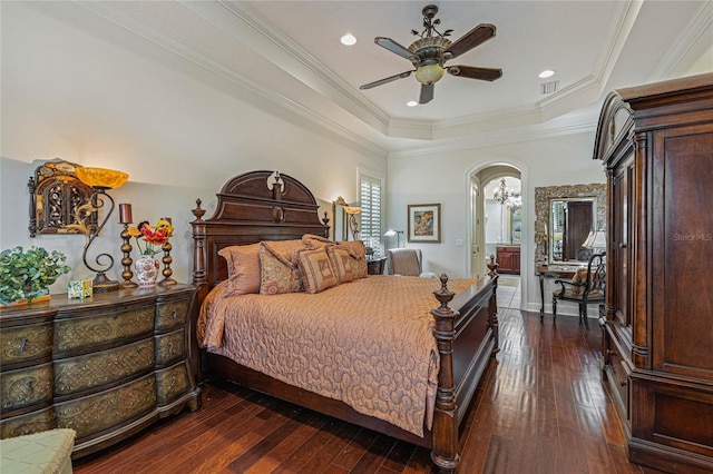 bedroom featuring ceiling fan, a raised ceiling, crown molding, and dark wood-type flooring