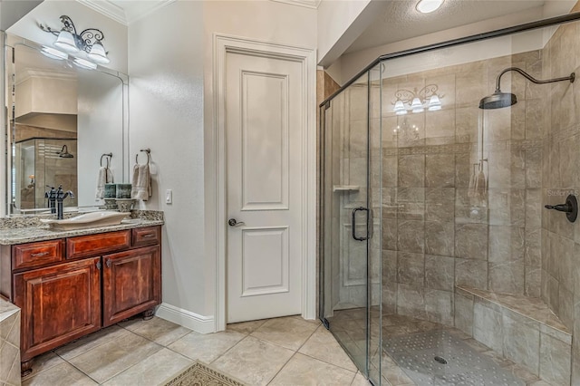 bathroom with walk in shower, vanity, crown molding, and tile patterned flooring