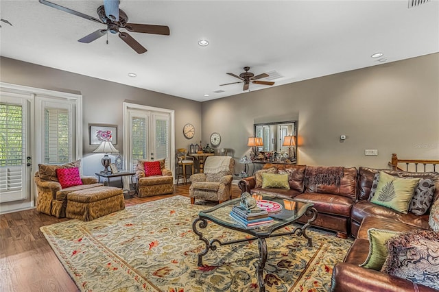 living room featuring wood-type flooring, ceiling fan, and french doors