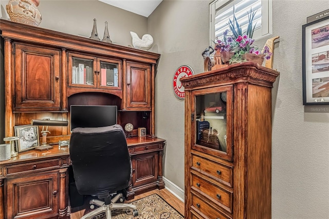 office space with light hardwood / wood-style flooring and built in desk