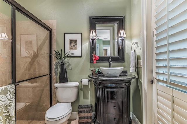 bathroom featuring vanity, toilet, an enclosed shower, and tile patterned floors