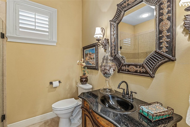 bathroom featuring walk in shower, vanity, tile patterned flooring, and toilet