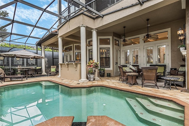 view of swimming pool featuring glass enclosure, ceiling fan, french doors, and a patio area