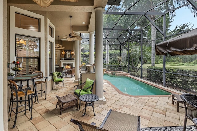 view of swimming pool featuring ceiling fan, an in ground hot tub, a lanai, and a patio area