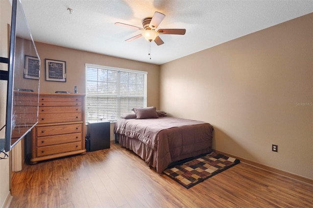 bedroom featuring wood-type flooring, a textured ceiling, and ceiling fan