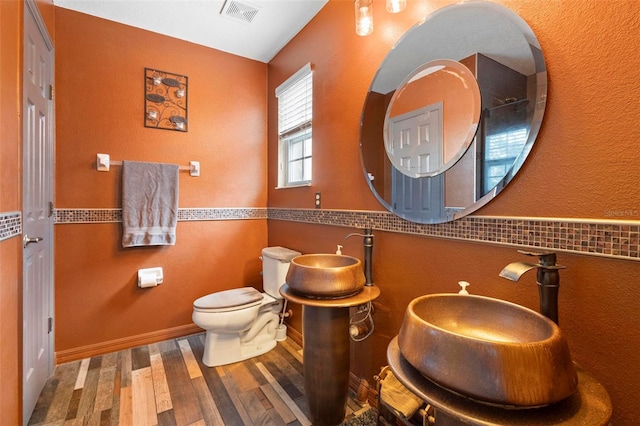 bathroom with toilet, sink, and hardwood / wood-style flooring